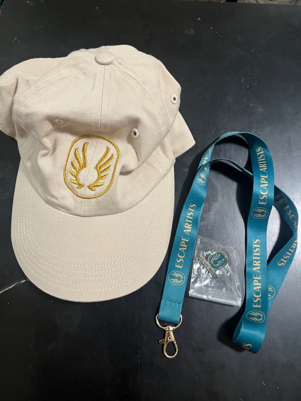 Escape Artists Beige Baseball Cap with Gold Emblem
